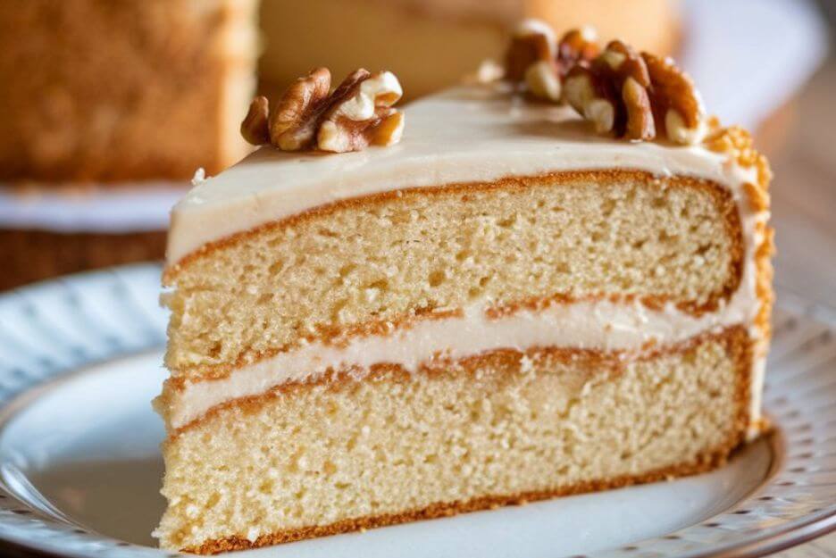 Million Dollar Cake slice topped with creamy frosting and pineapple chunks