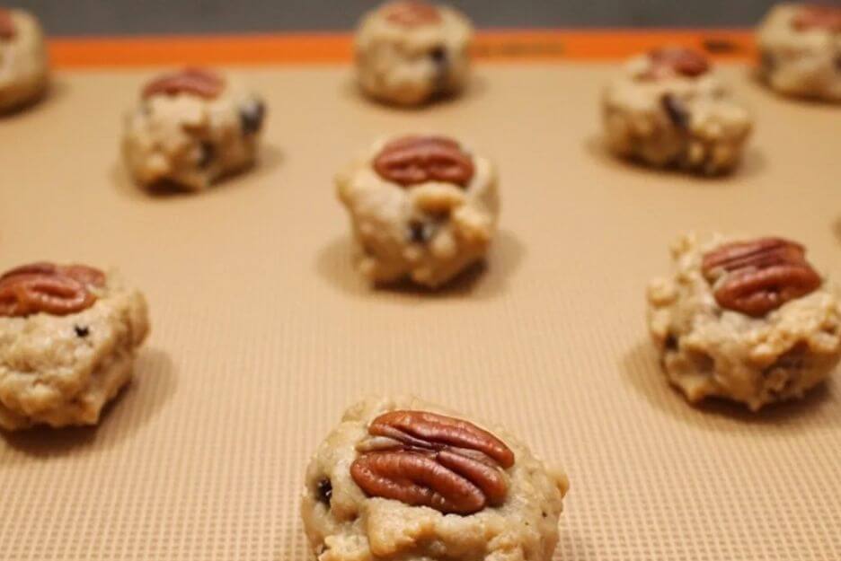 press a perfect pecan half gently into the center of each dough ball