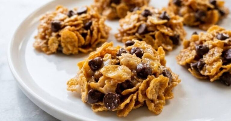 Golden brown cornflake cookies with dark chocolate chips on a white plate, showcasing a 4-ingredient no-bake recipe.